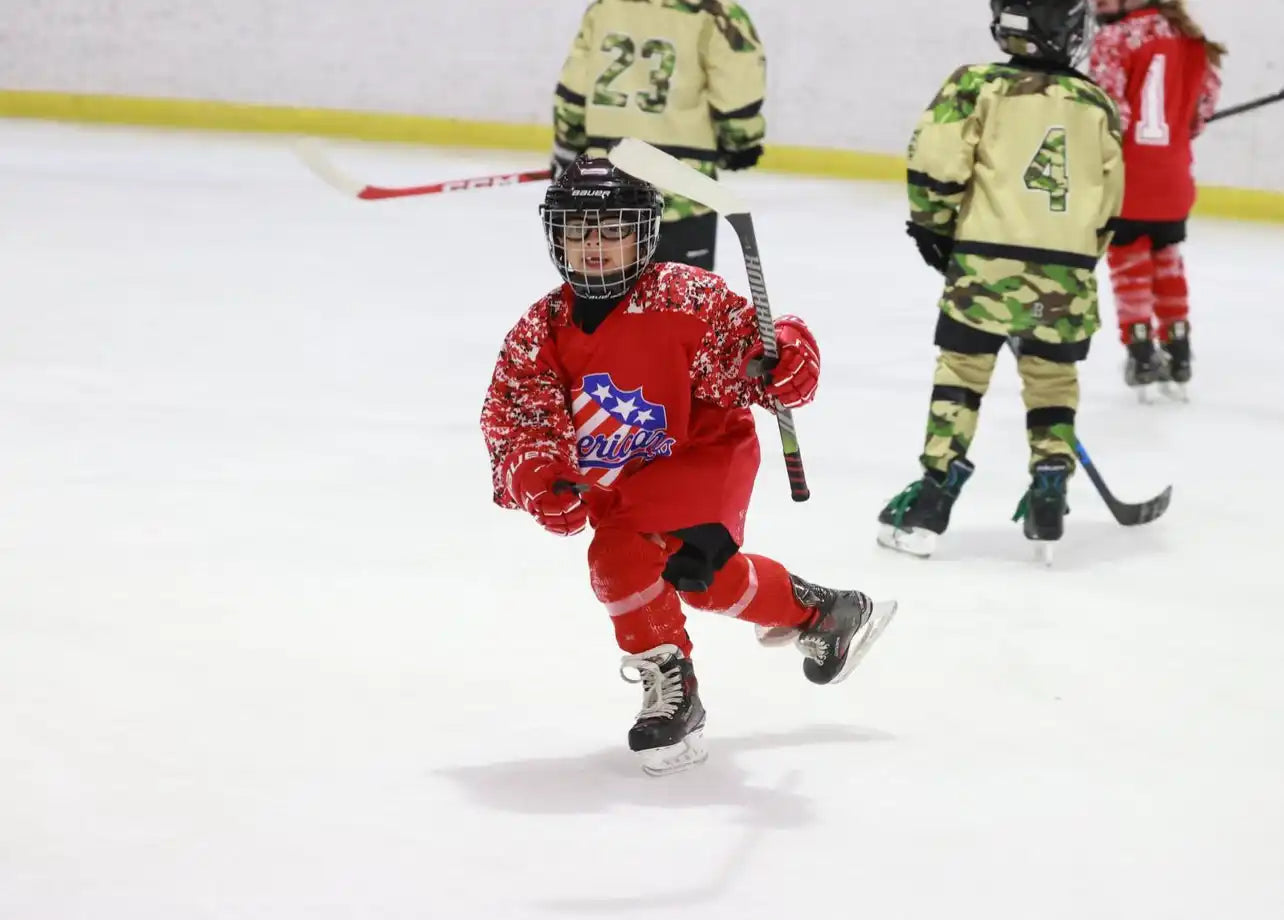 Red hockey jersey with white stars and blue stripes, black helmet, gray skates.